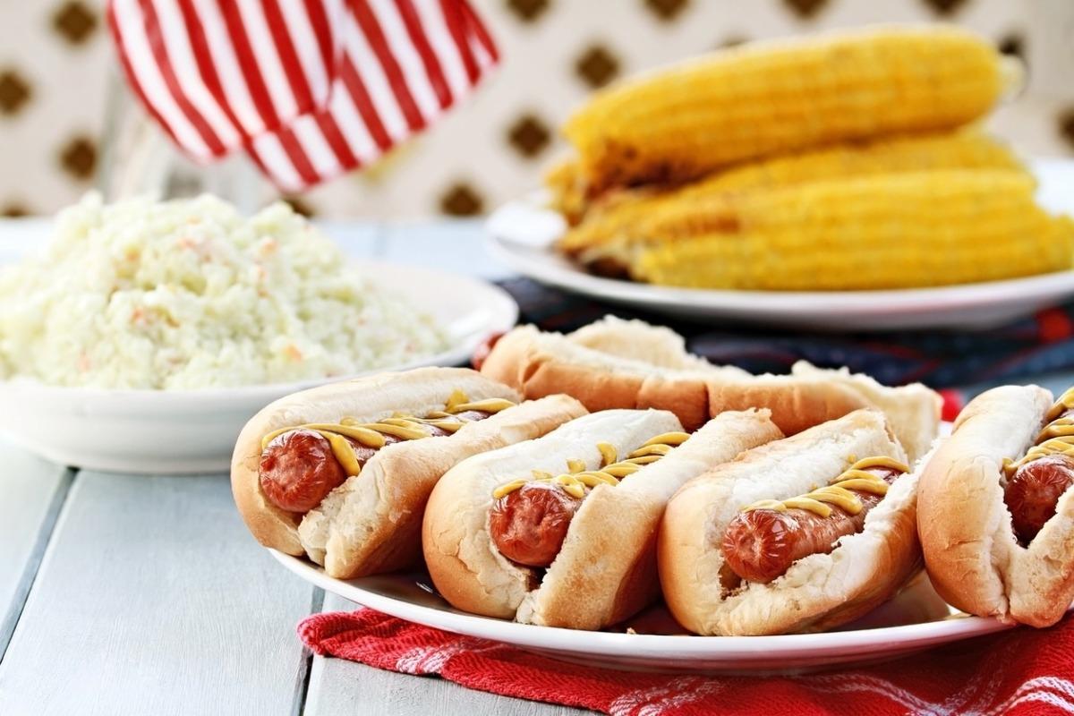 a cookout picnic at grande shores ocean resort with coleslaw, hotdogs and corn on the cob.