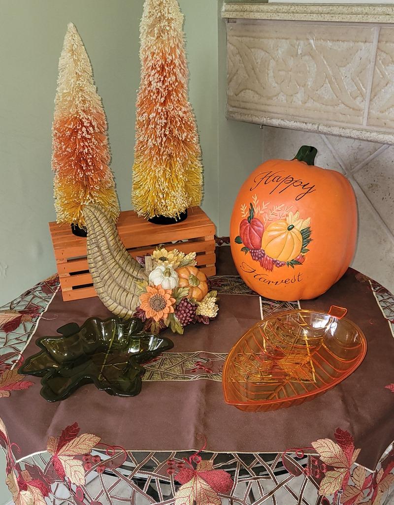 Fall decor including colorful trees and pumpkins