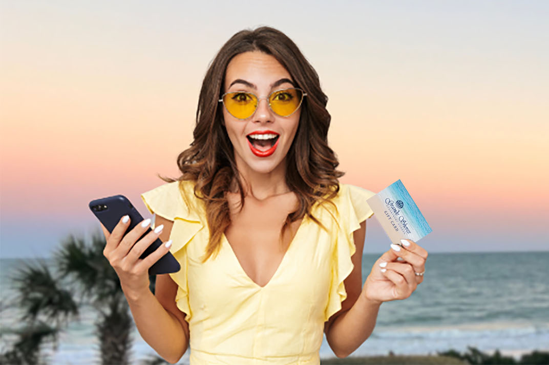 An excited young woman with wavy hair stands in the foreground, holding a smartphone in one hand and a boarding pass in the other
