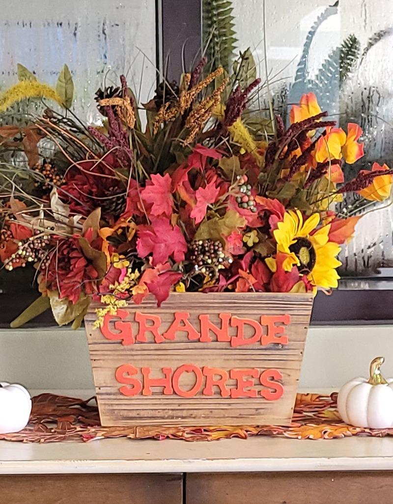 Fall decor with Grande Shores painted in letters on a basket