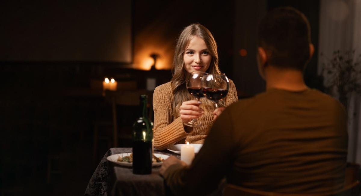 romantic dining couple at a nice sit down restaurant with a glass of wine celebrating Valentine's Day