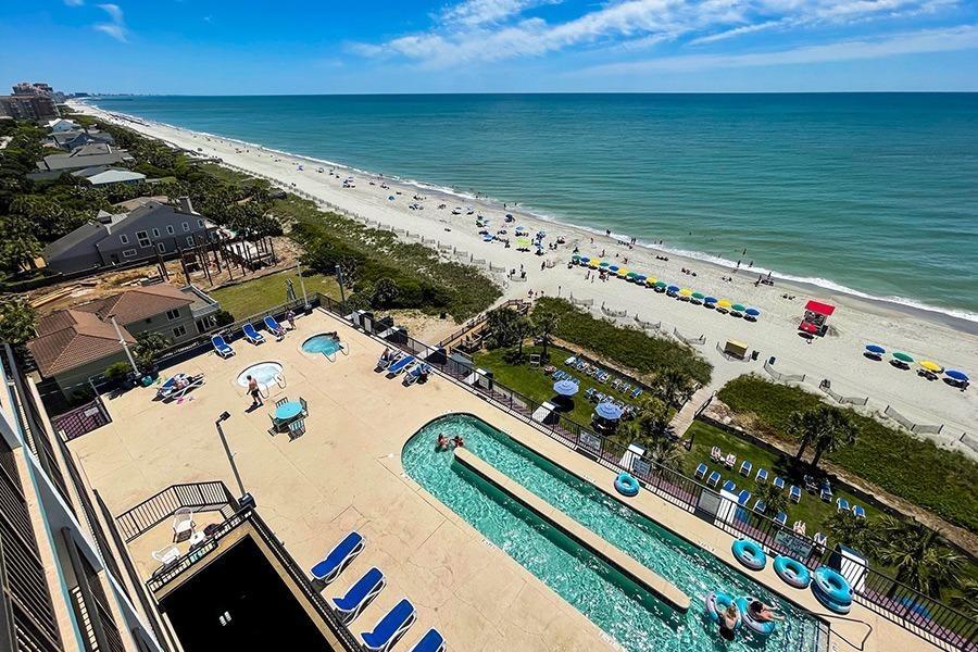 aerial view of a rooftop pool deck at grande shores with lazy river and views of the beach and ocean